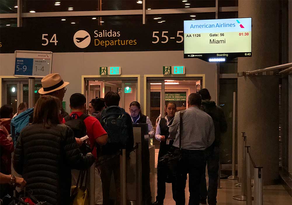 Departure gate, sign says American Airlines flight to Miami.