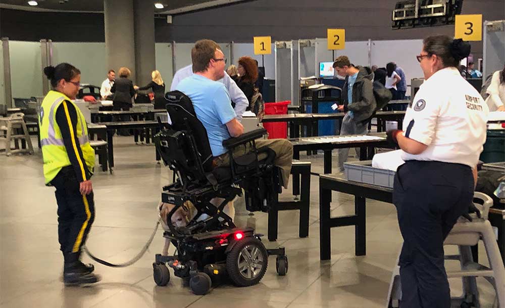 Drug-sniffing dog inspecting a power wheelchair.