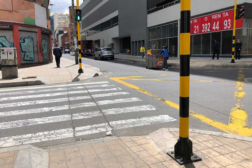 Street crossing with curb cuts and pedestrian signal.