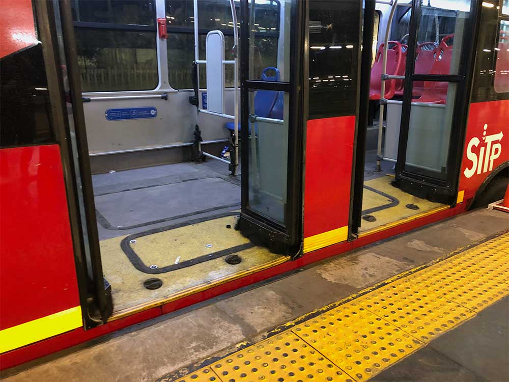 City bus parked alongside station platform.