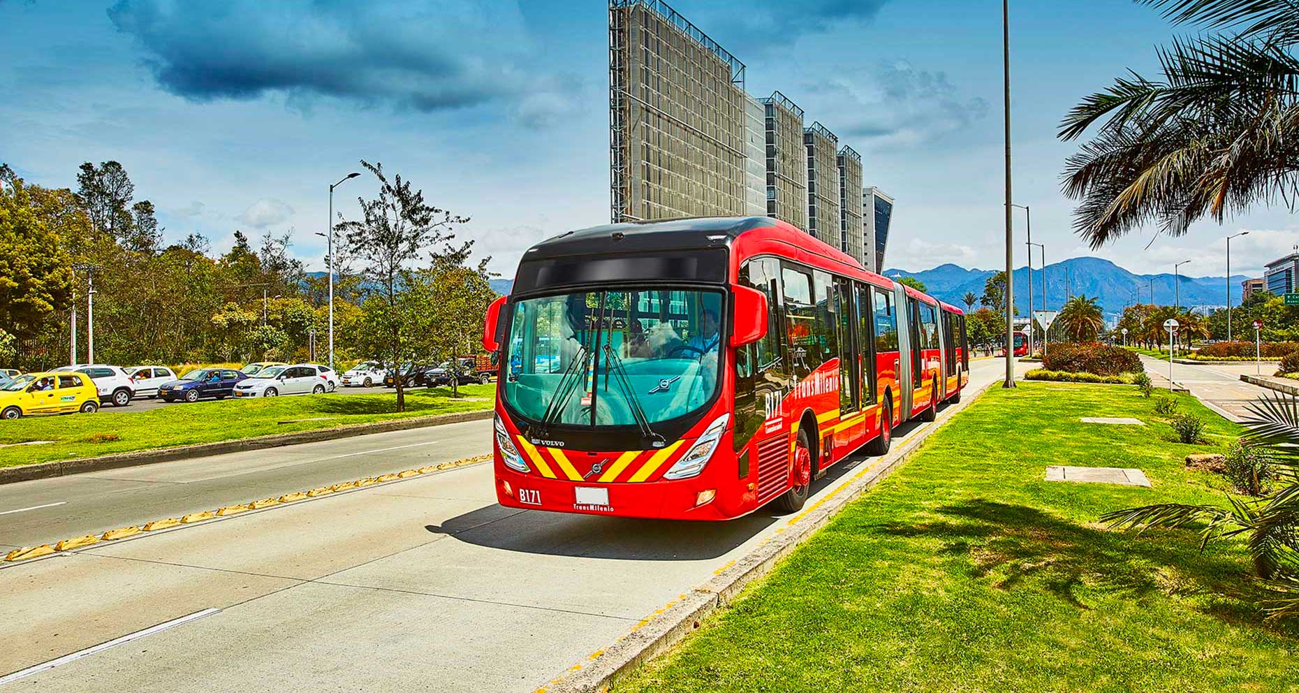 Red city bus driving down street in Bogota, Colombia.