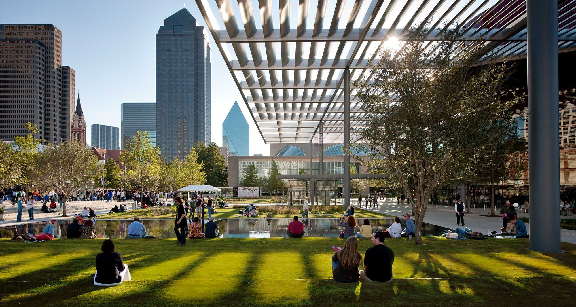 Public park in downtown Dallas, Texas, with trees, grass and shaded areas.