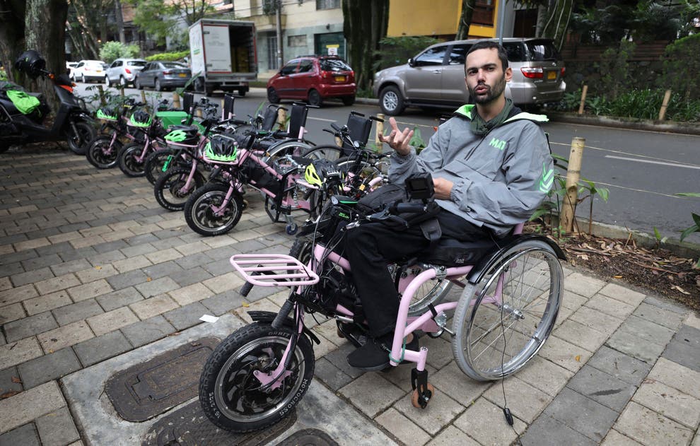 Wheelchair user with electric hand bike attachment.