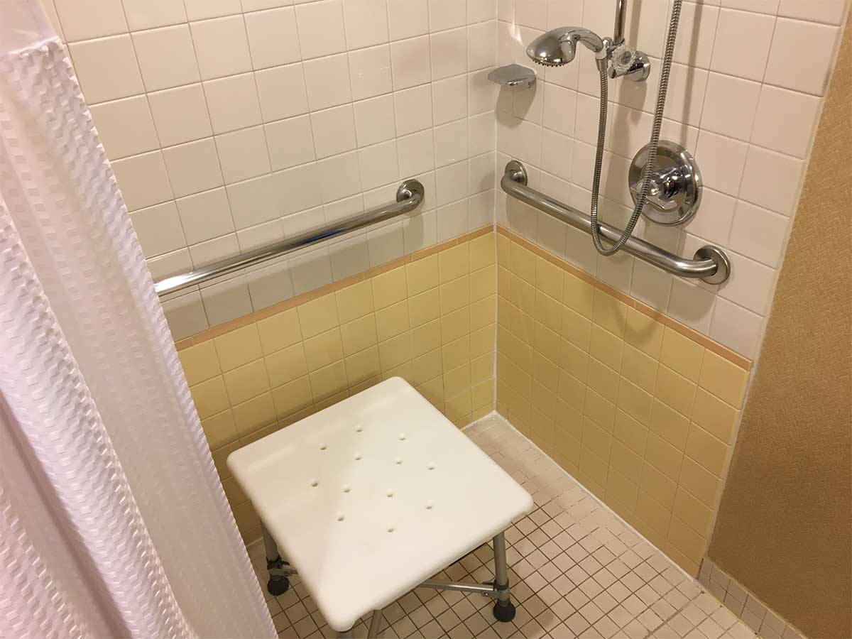 Plastic square bench in roll-in shower.