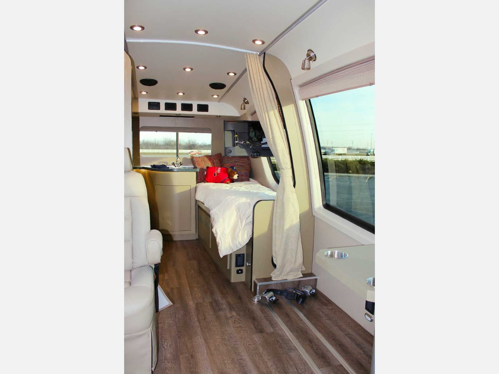 Wide pathway and bed inside van.