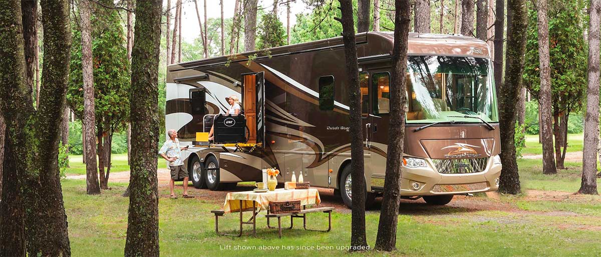 Woman in wheelchair using lift to access accessible RV camper.