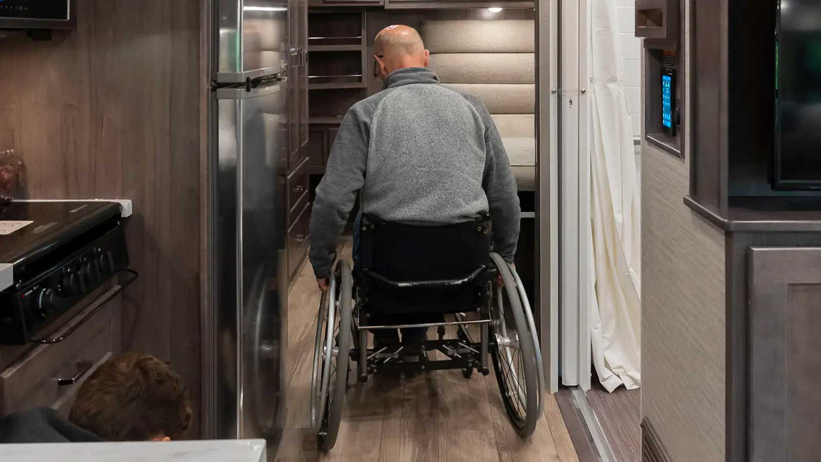 Wheelchair user rolling down RV hallway.