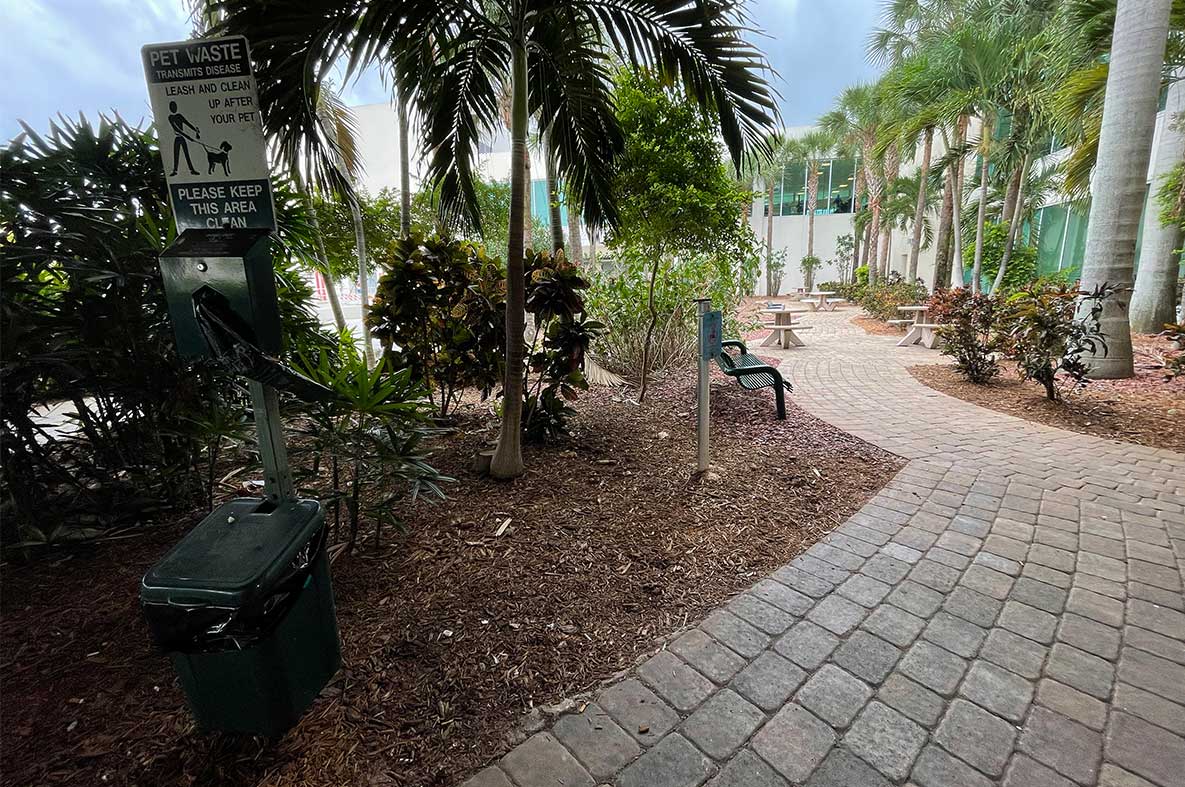 Outdoor service animal relief area with mulch area and bag dispenser for cleanup.