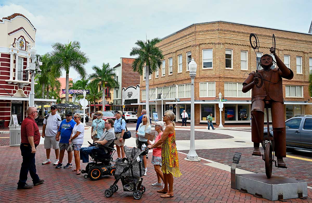 Tour guide speaking to group of people in front of a historic building.