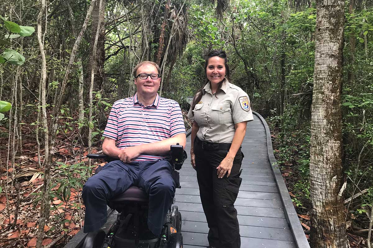 John in wheelchair sitting next to park ranger.