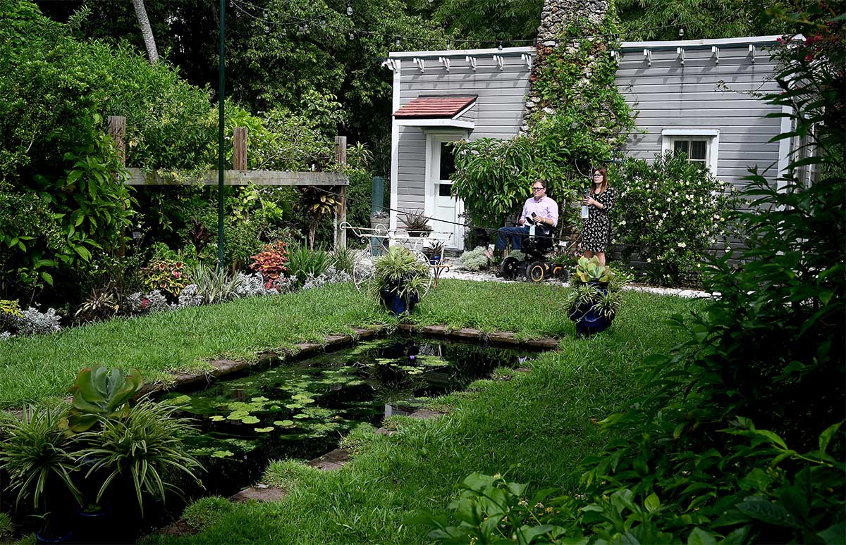 John and tour guide looking at lily pond and garden.