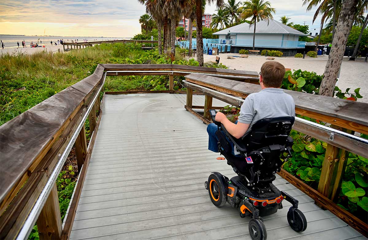 John in wheelchair on wooden ramp.