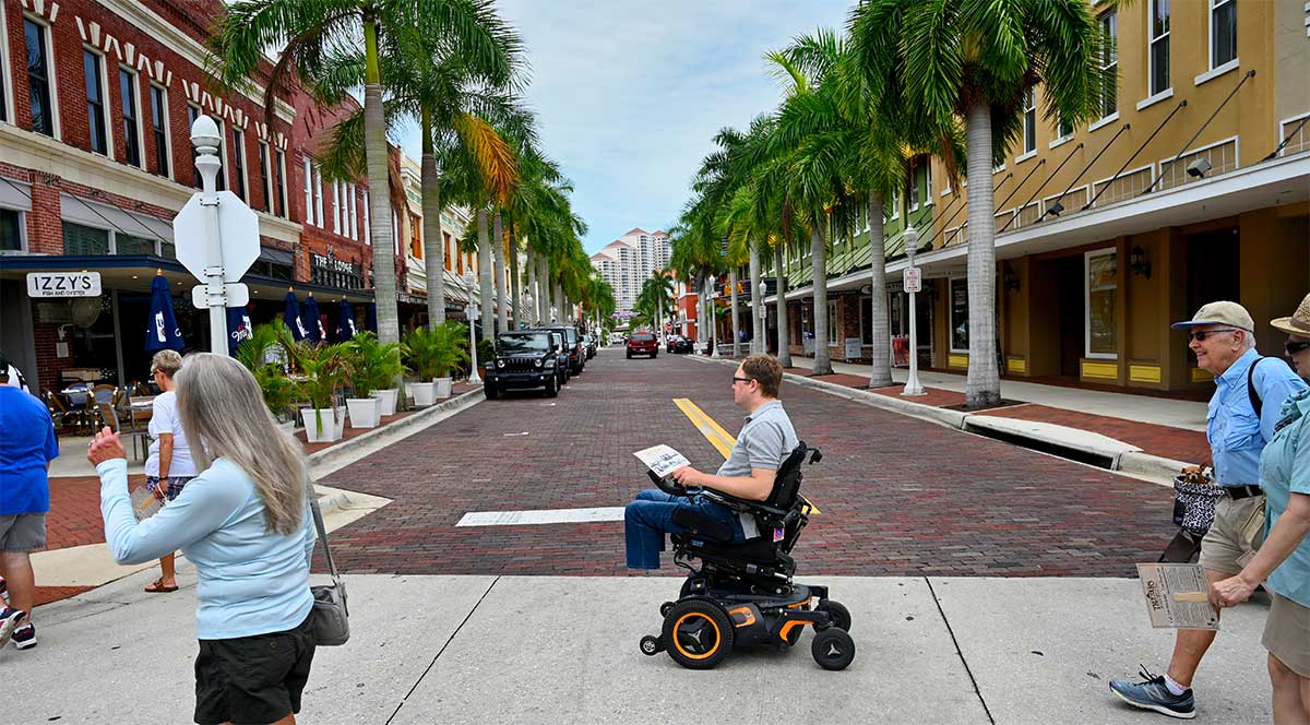 John rolling in his wheelchair in a crosswalk.