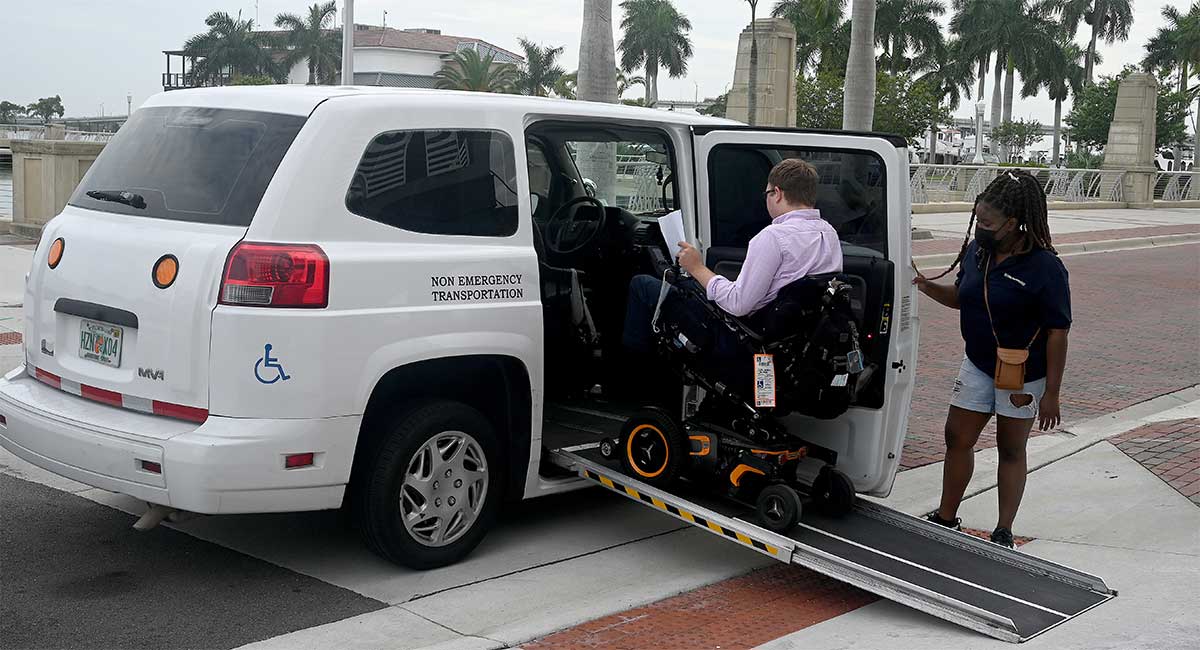 Wheelchair user going up ramp of taxi van.