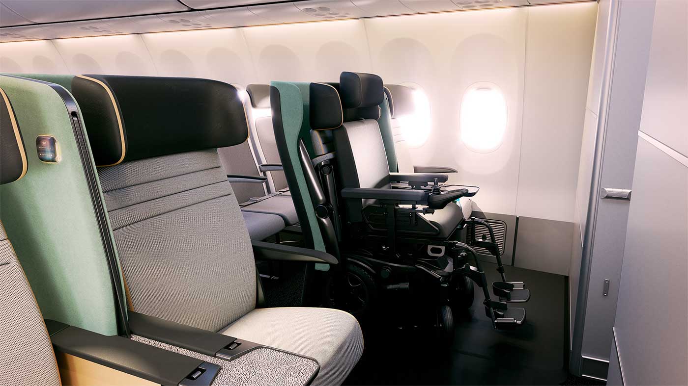 Power wheelchair secured in space where the front row aisle seat is typically located.