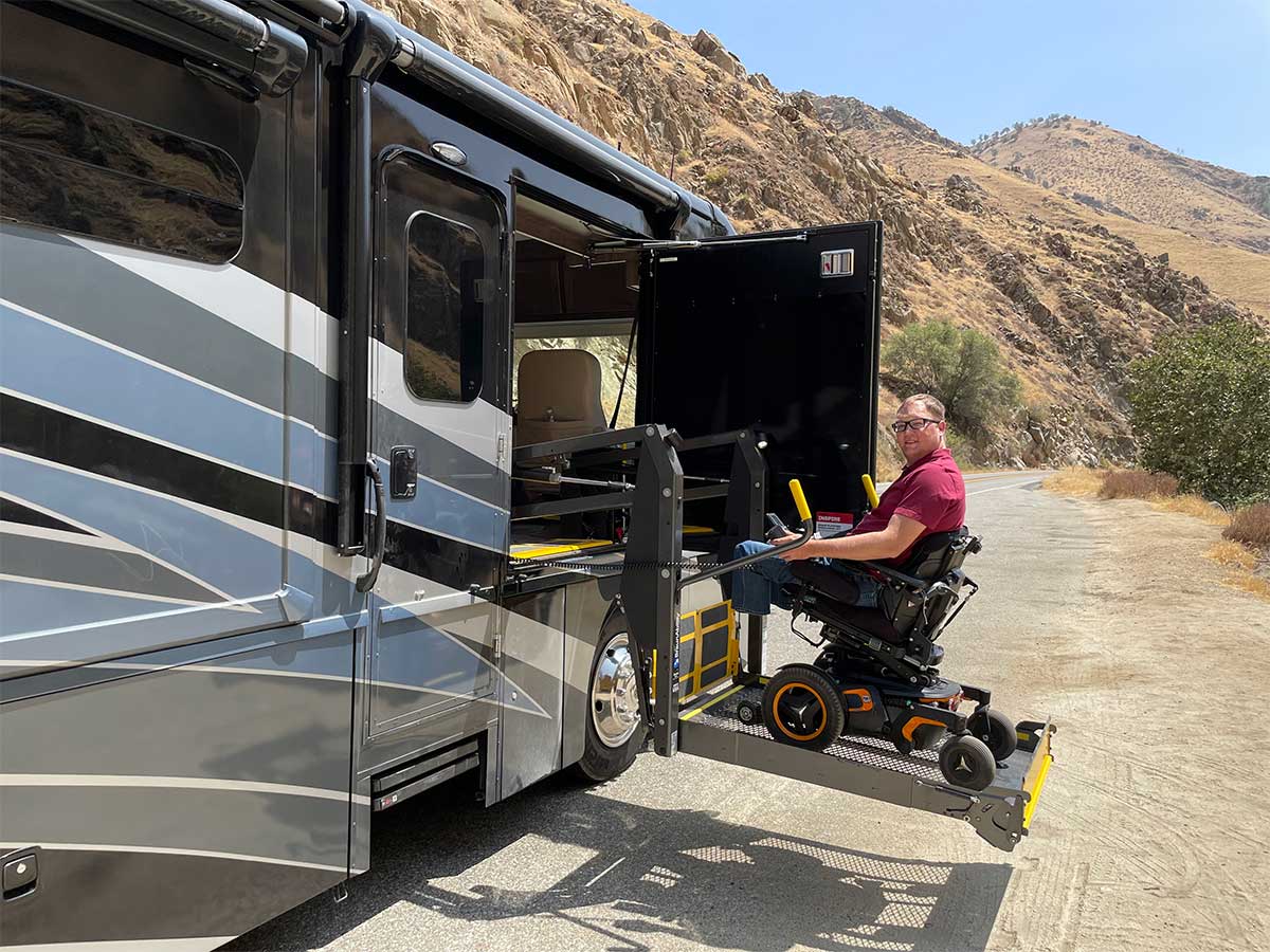 John and wheelchair on wheelchair lift entering the RV.