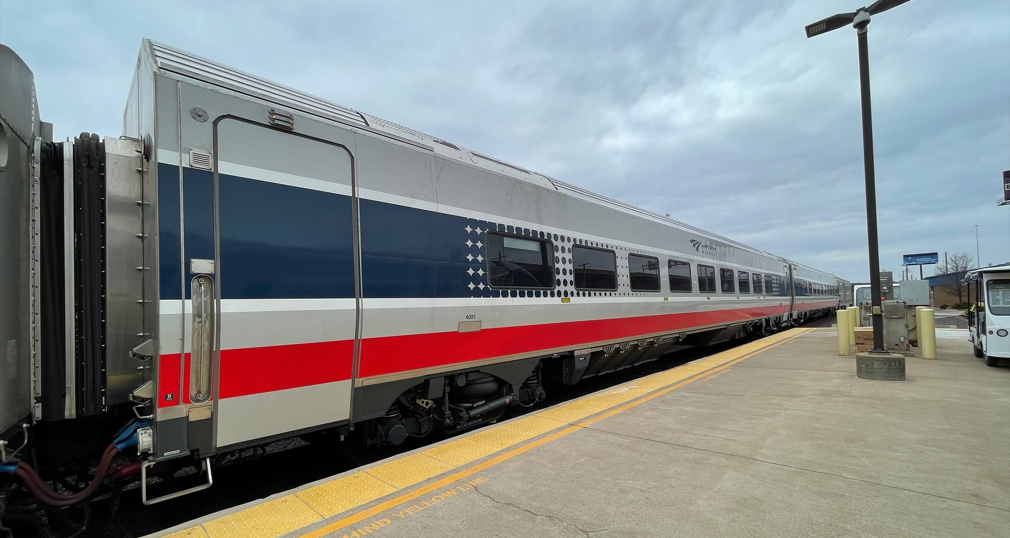 Amtrak Venture Car parked at low platform station.