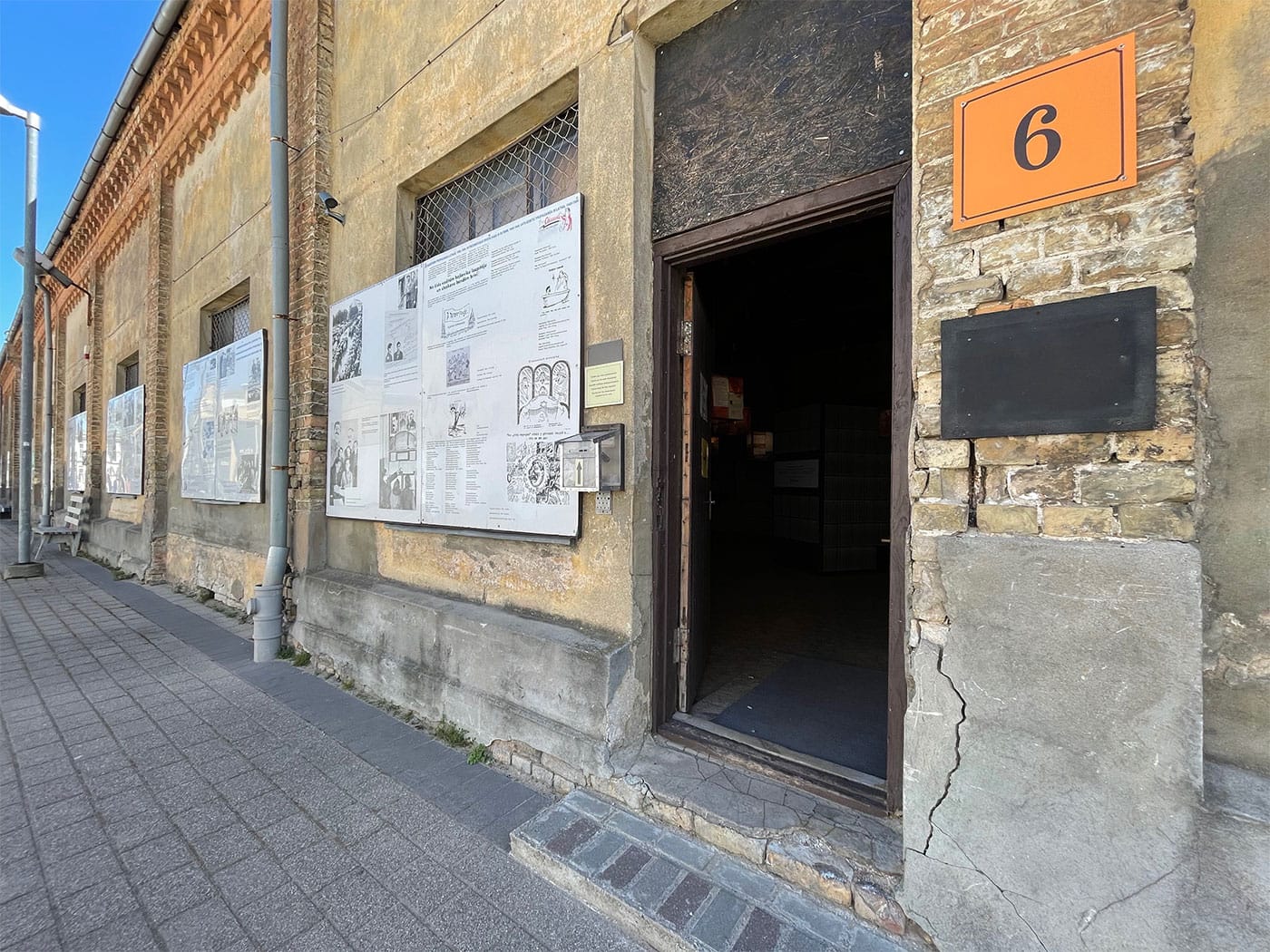 Exhibit panels on outside of building and stepped entrance to interior of building.