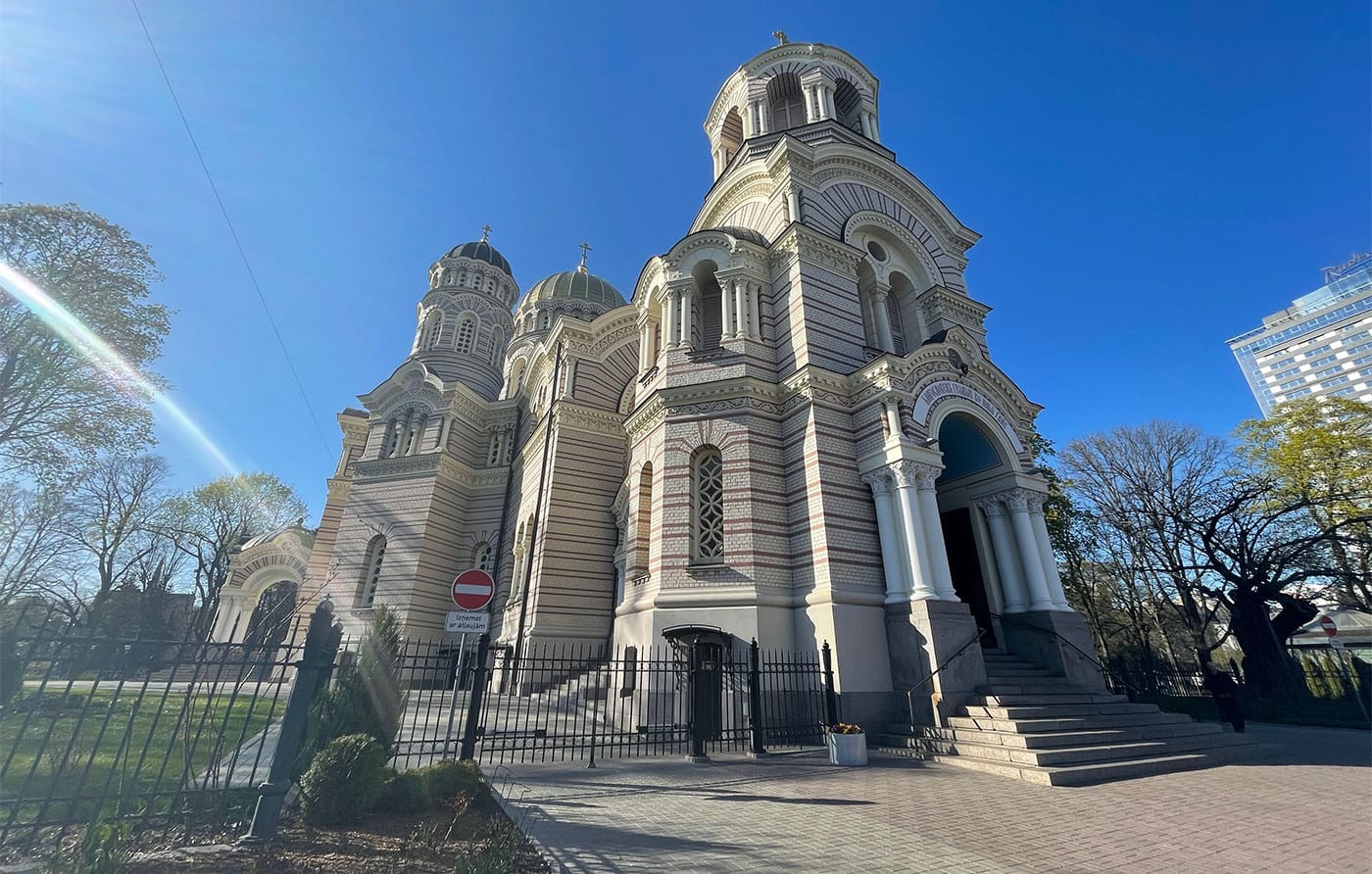 Orthodox cathedral with golden domed top and stairs leading to entrance.