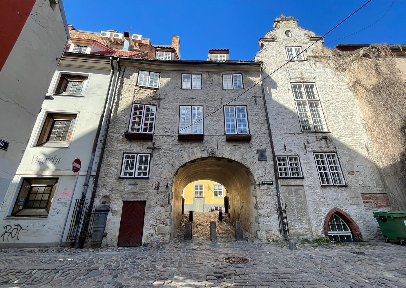 Cobblestone street leading through an archway.