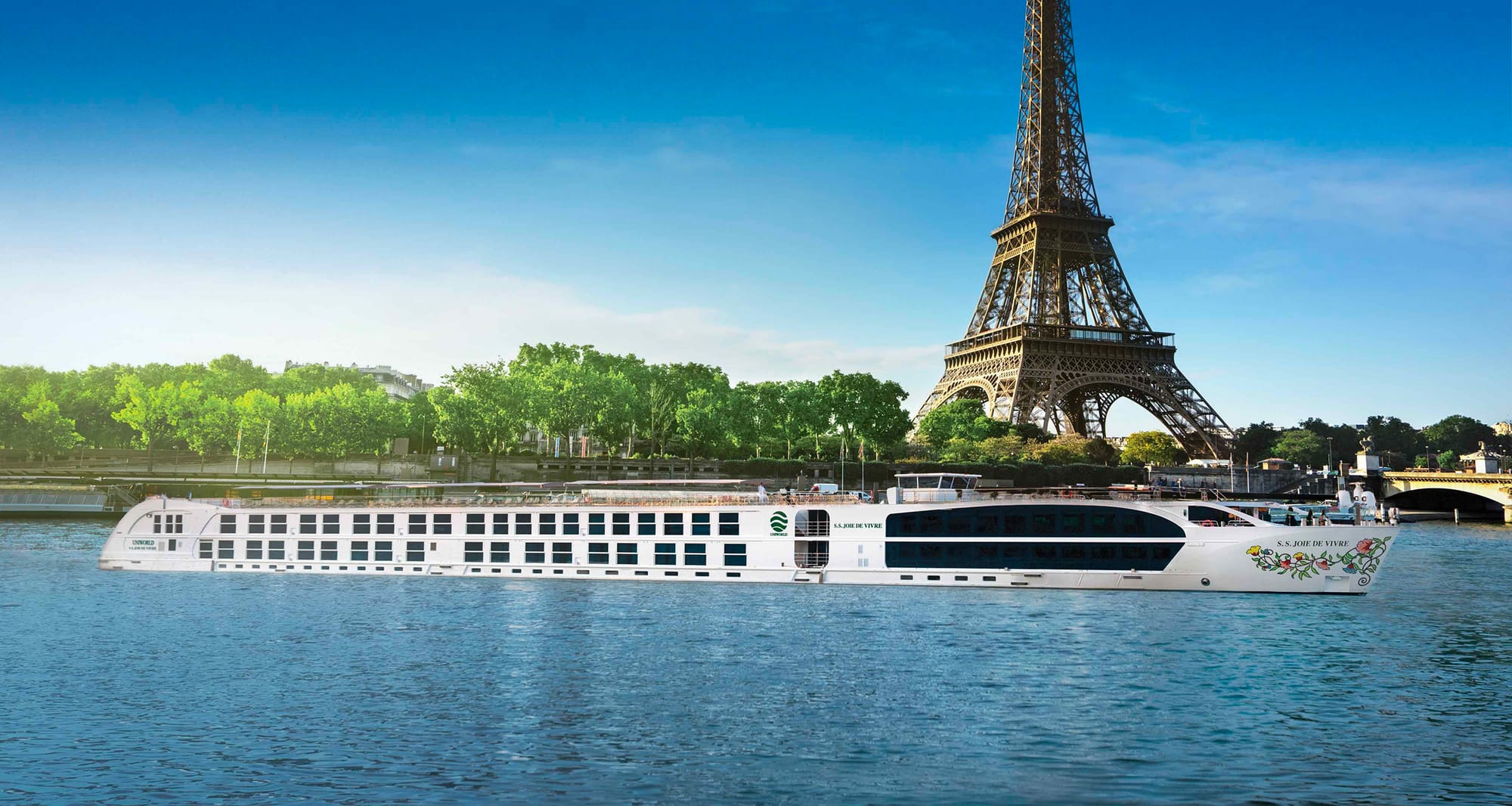 Joie de Vivre river boat passing by the Eiffel Tower.