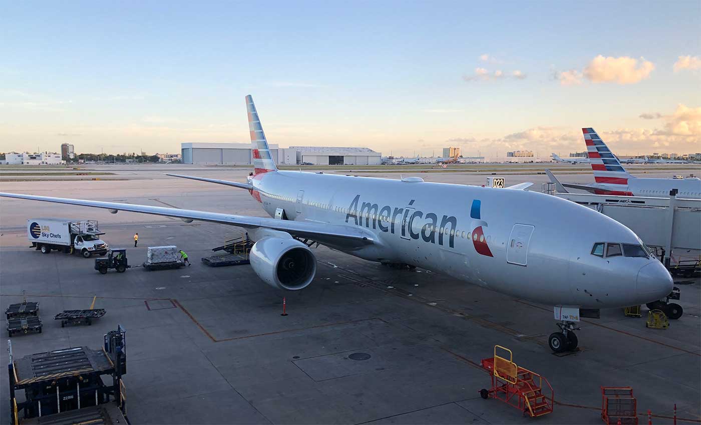 American Airlines Boeing 777 aircraft parked at Miami Airport gate.