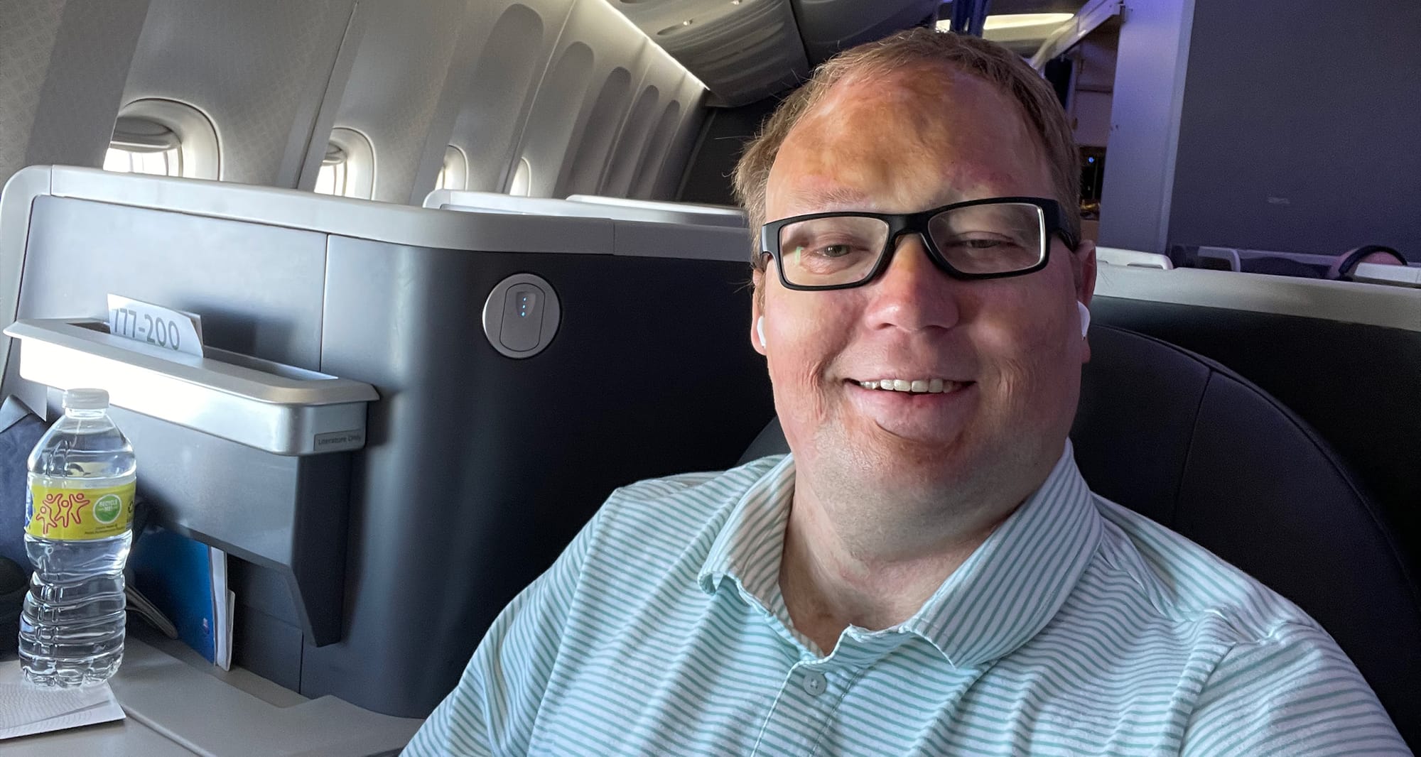 Man seated in business class seat.