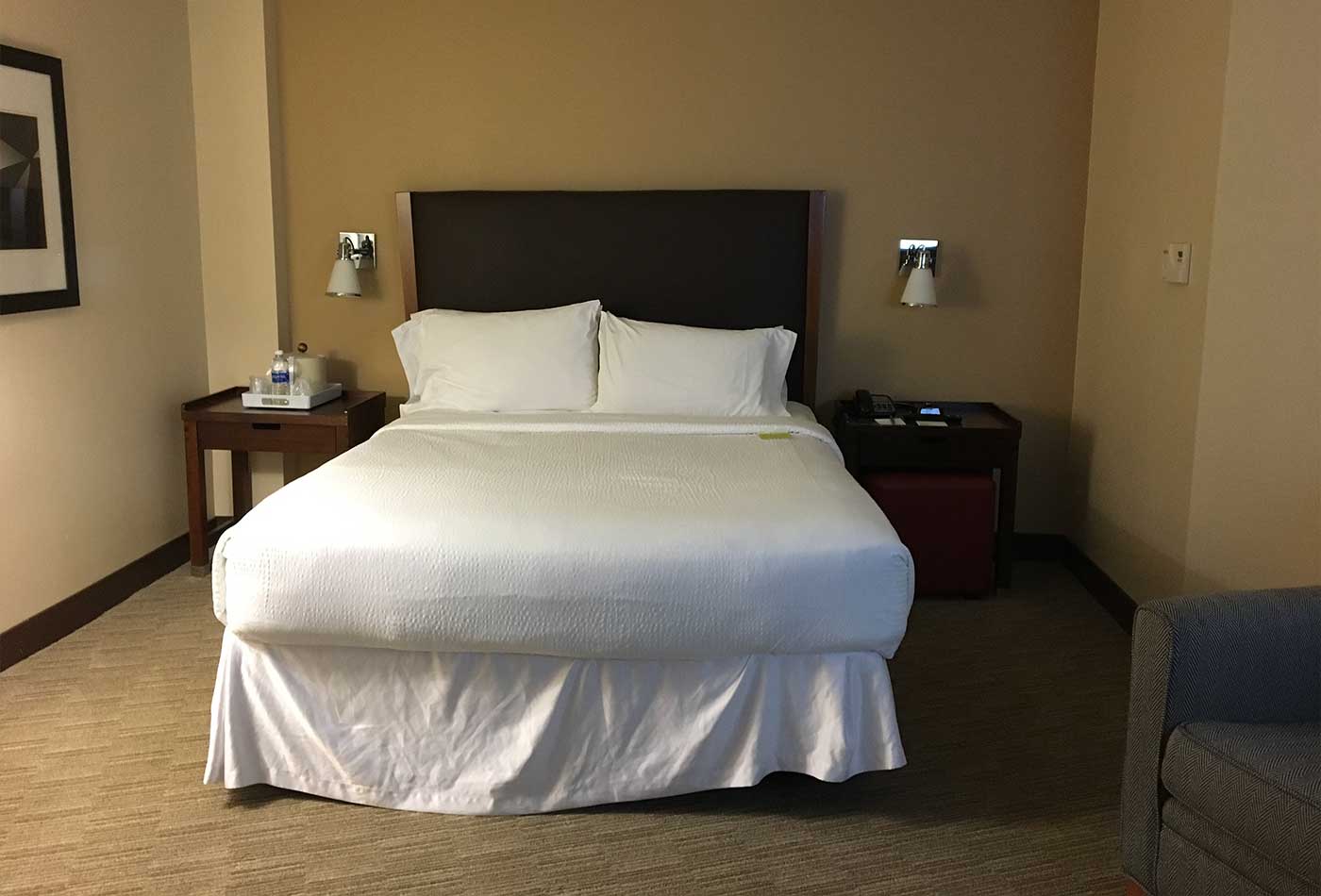 Queen size bed in hotel room.