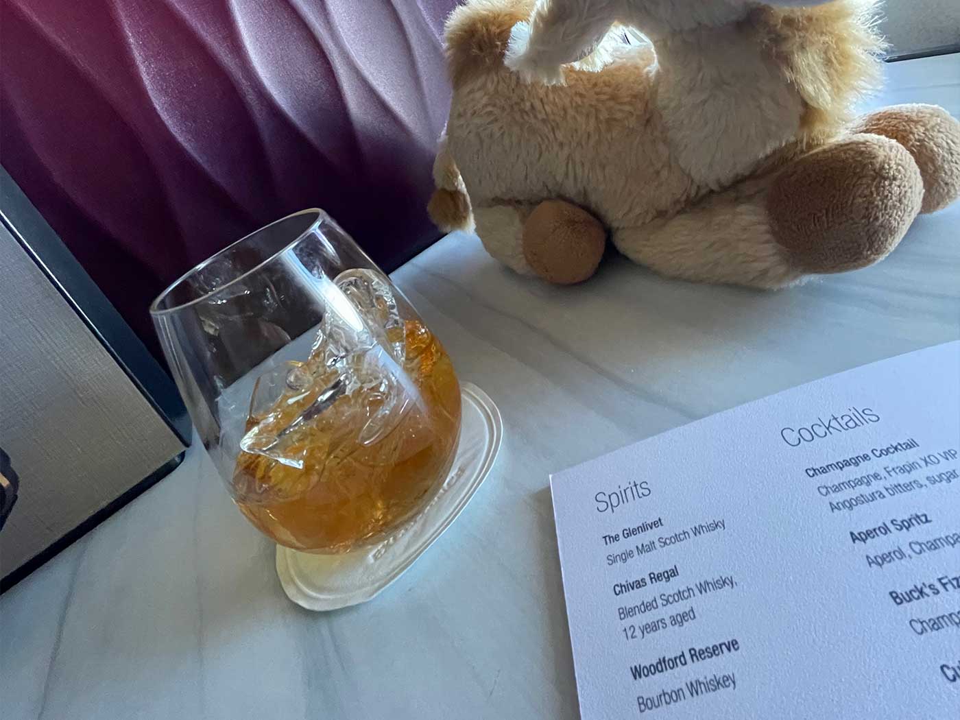 Close-up view of drink menu and a glass of bourbon.