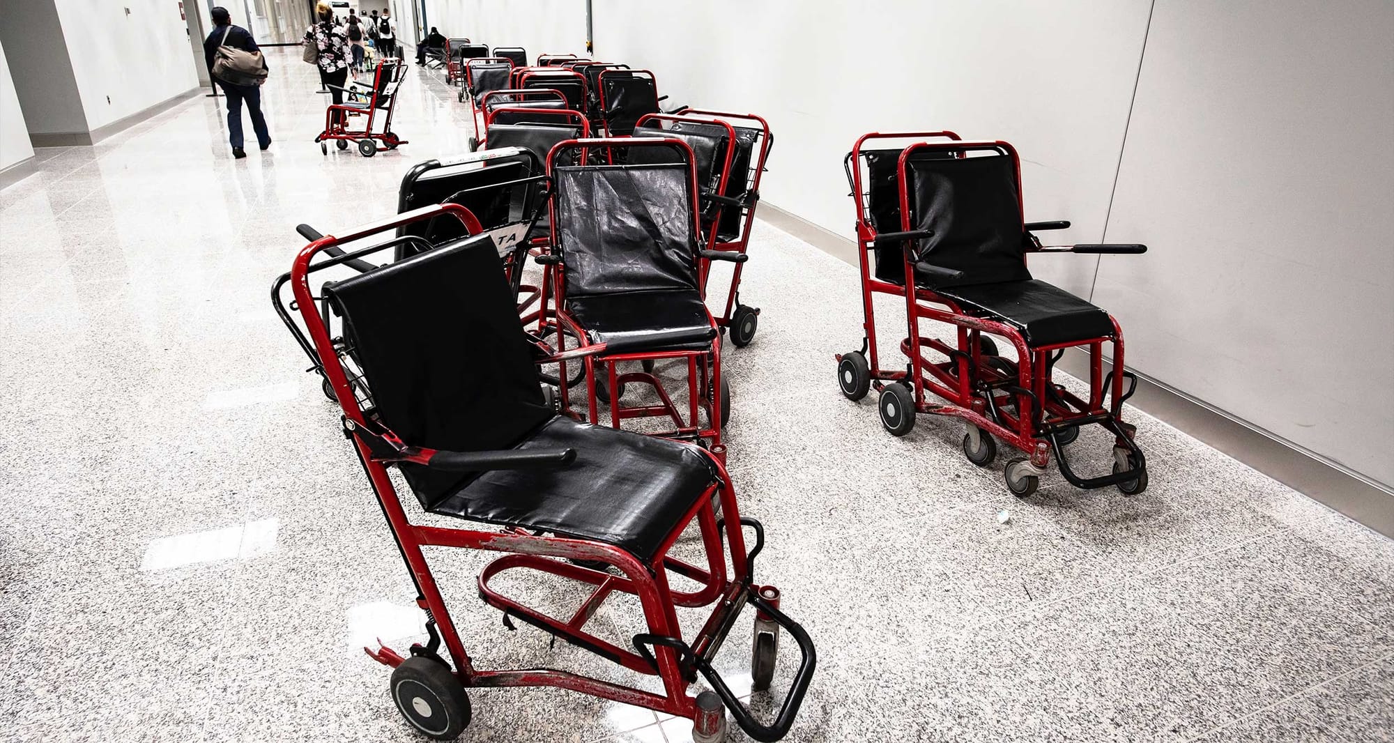 Airport wheelchairs abandoned in a hallway.