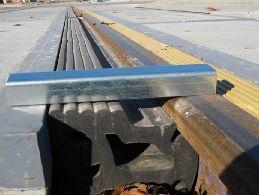 Rubber gap filler shown between the roadway and rail.