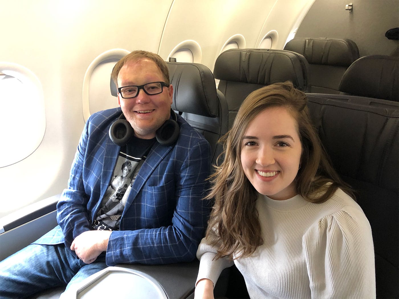 John seated next to his sister on an airplane.