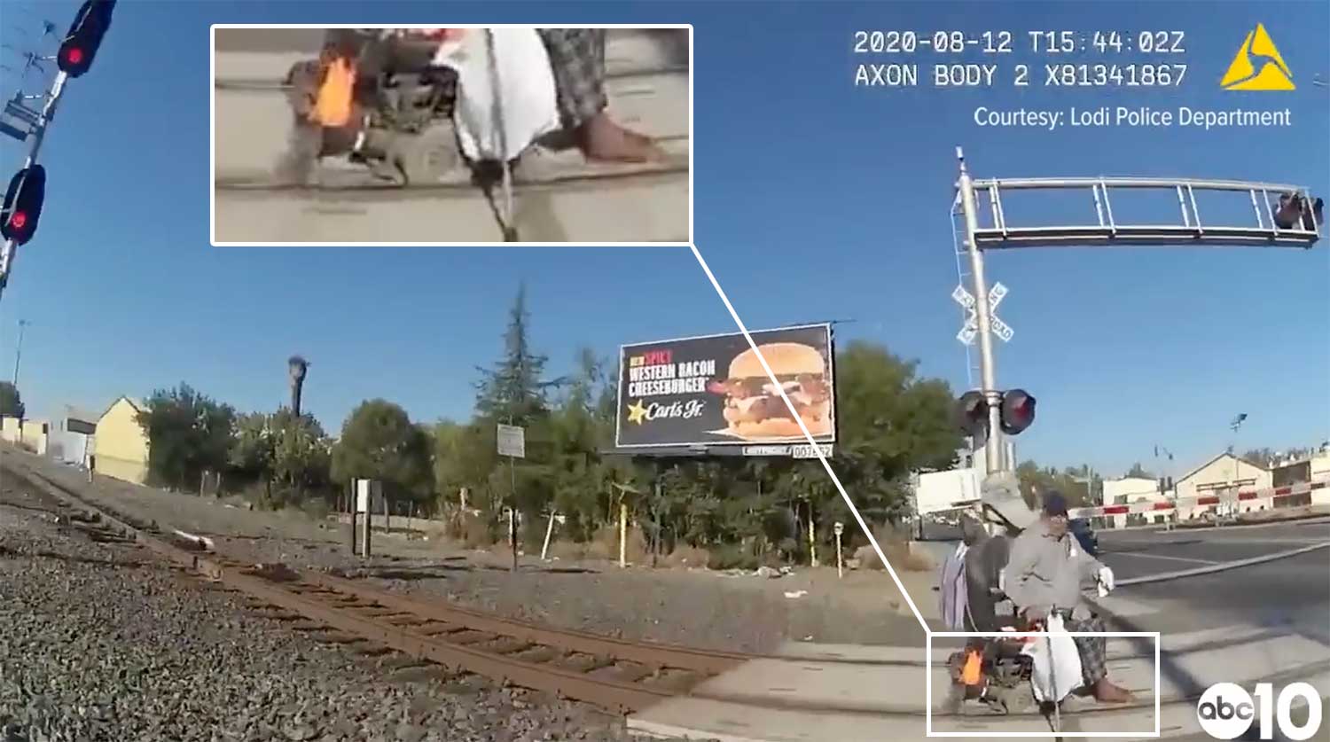 Zoomed in image of a wheelchair's tires stuck in the gap between the railroad track and sidewalk surface.