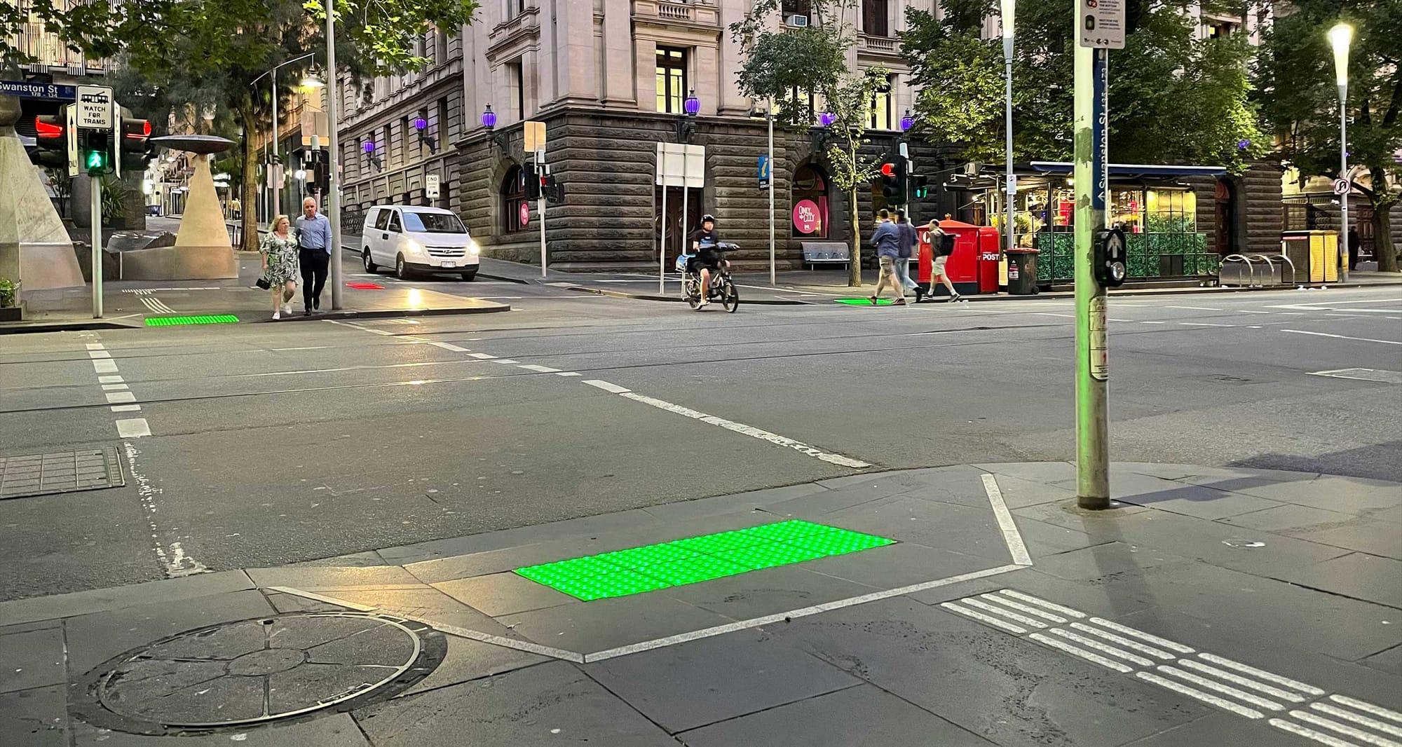 Crosswalk with colored LED warning lights embedded in curb ramp.