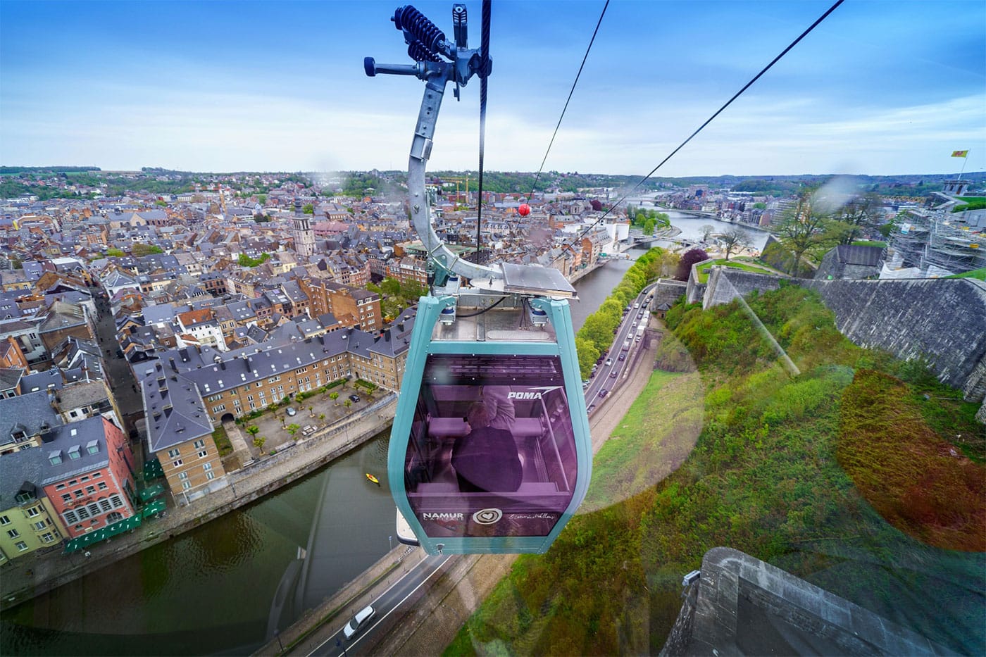 Namur Cable Car moving on cable line toward city below hilltop.