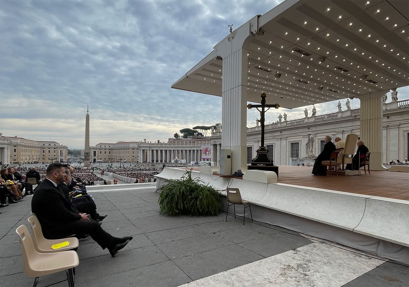 Pope Francis seated on a chair from the papal speaking platform overlooking Saint Peter's Square.