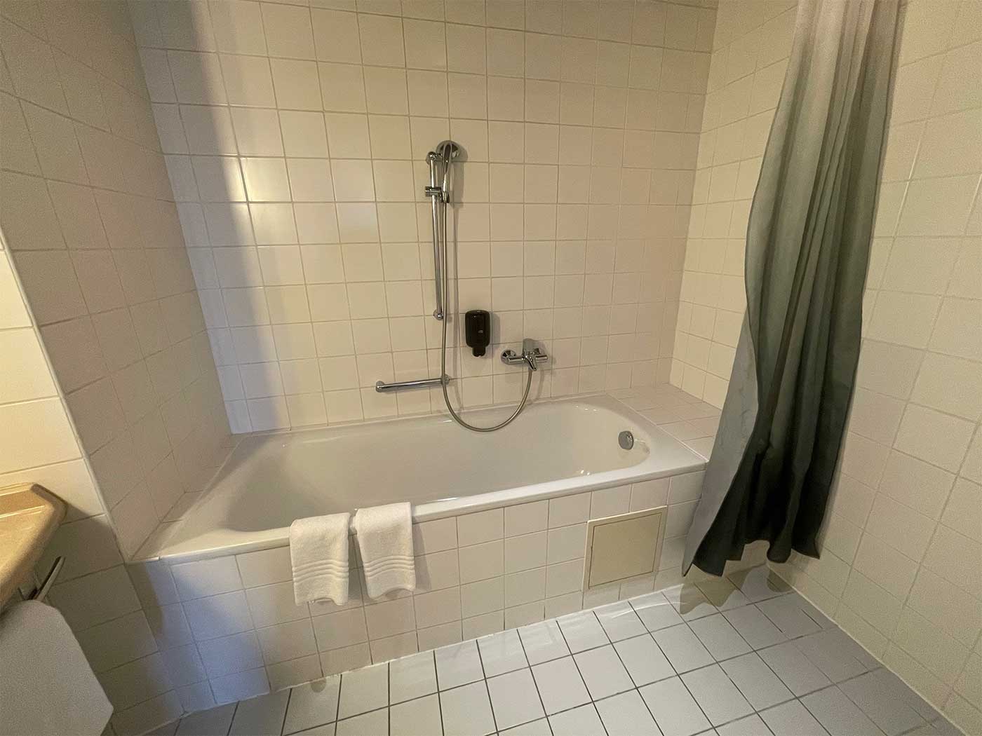 Bathtub with seat behind tub.