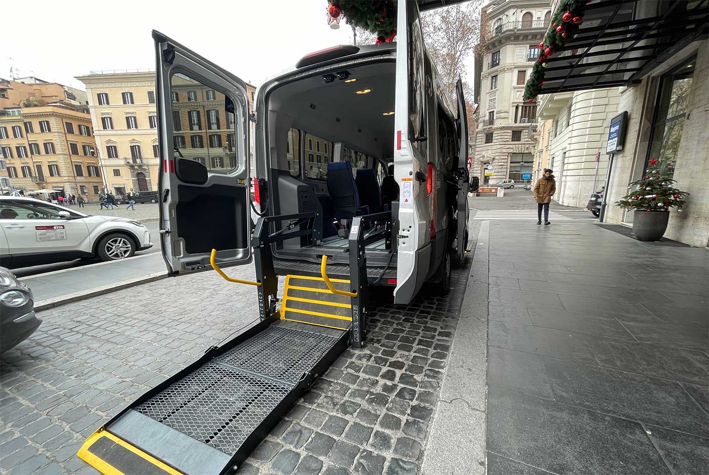 Wheelchair accessible van with wheelchair lift deployed from rear.