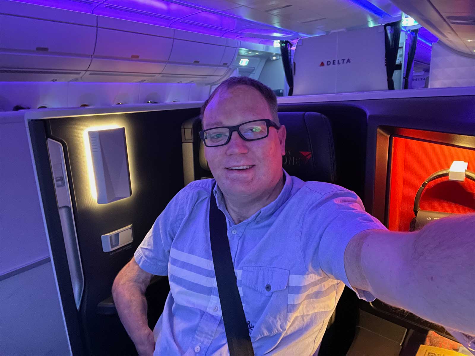 John taking a selfie in the business class seat.