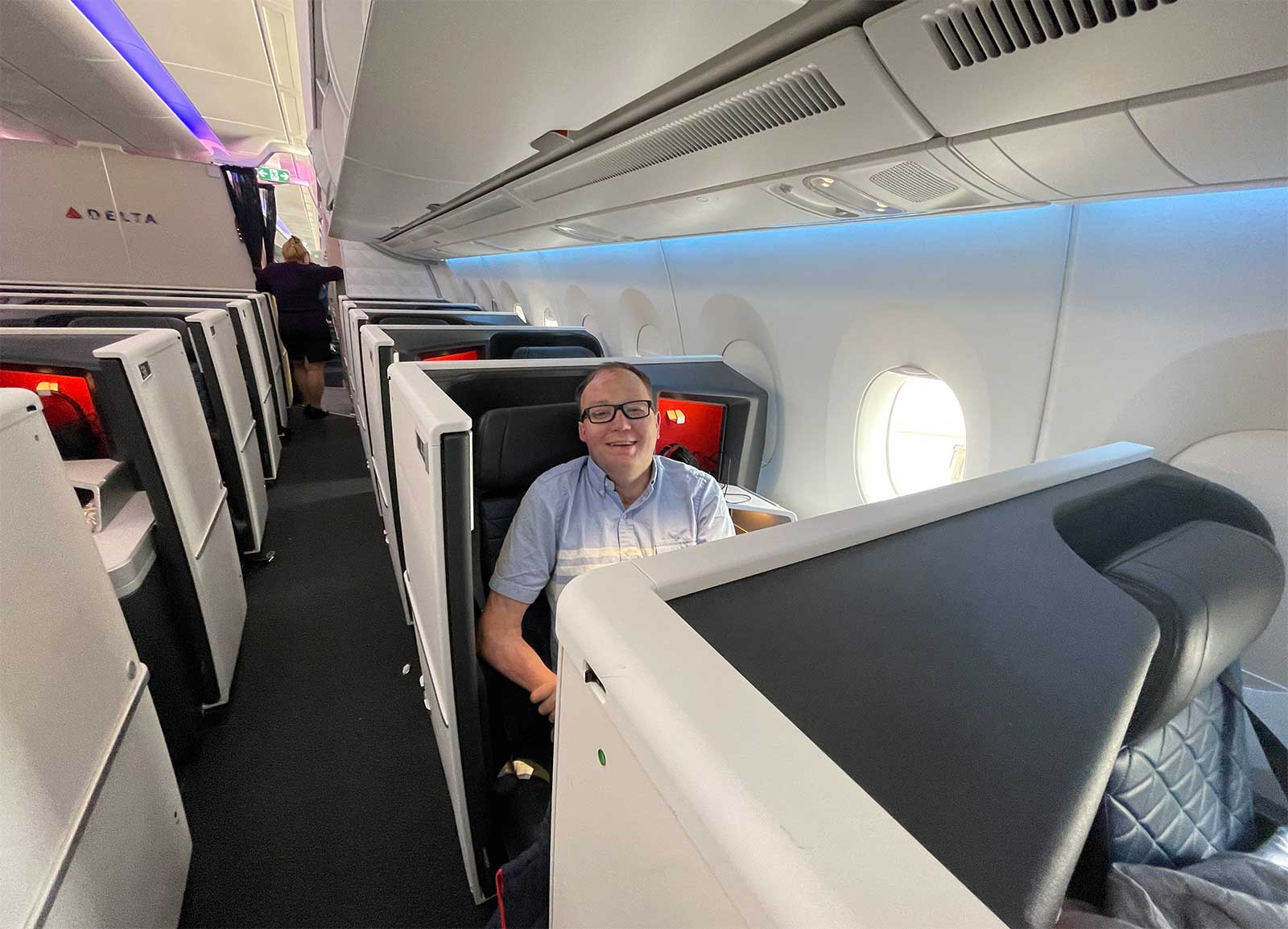 John seated in an enclosed business class suite.