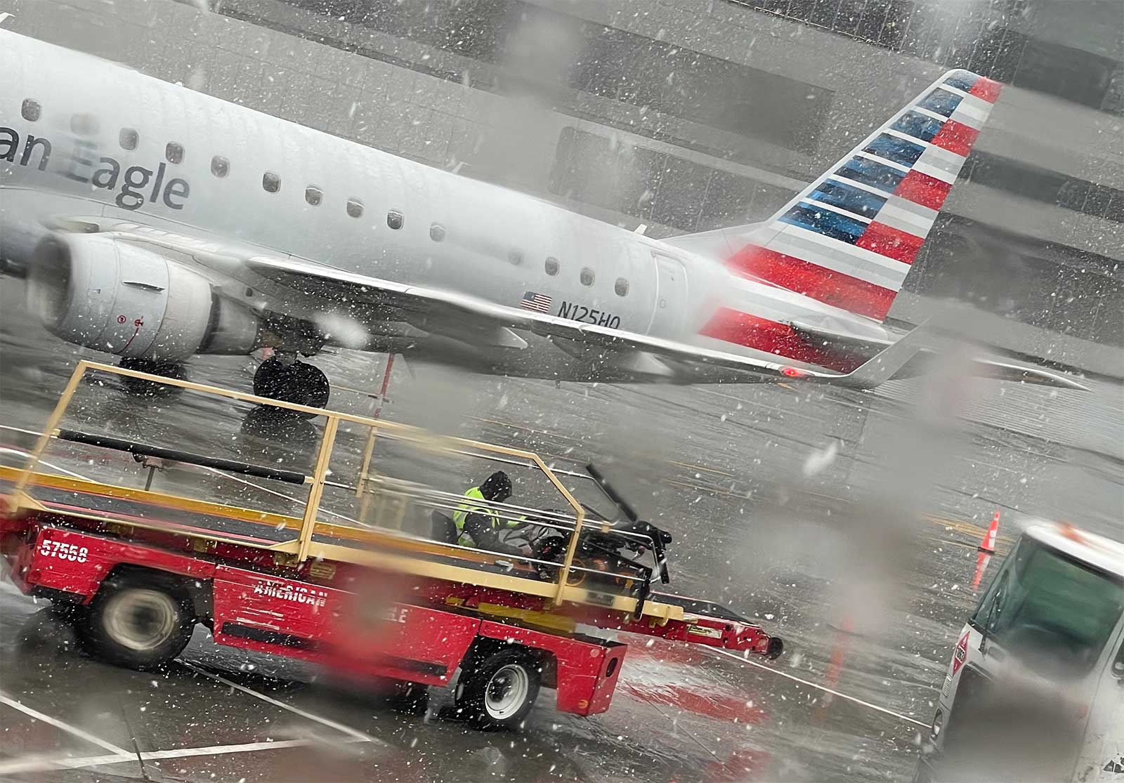 Wheelchair on airline luggage loader out in the rain and snow.