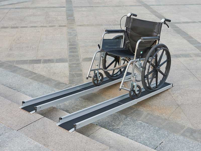 Manual wheelchair on telescopic two piece ramp.