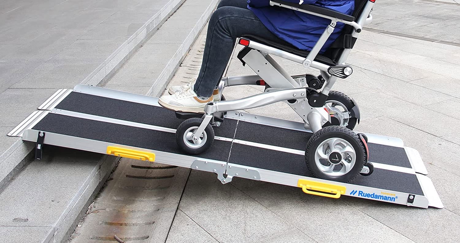 Wheelchair user rolling up a 6-foot portable ramp.