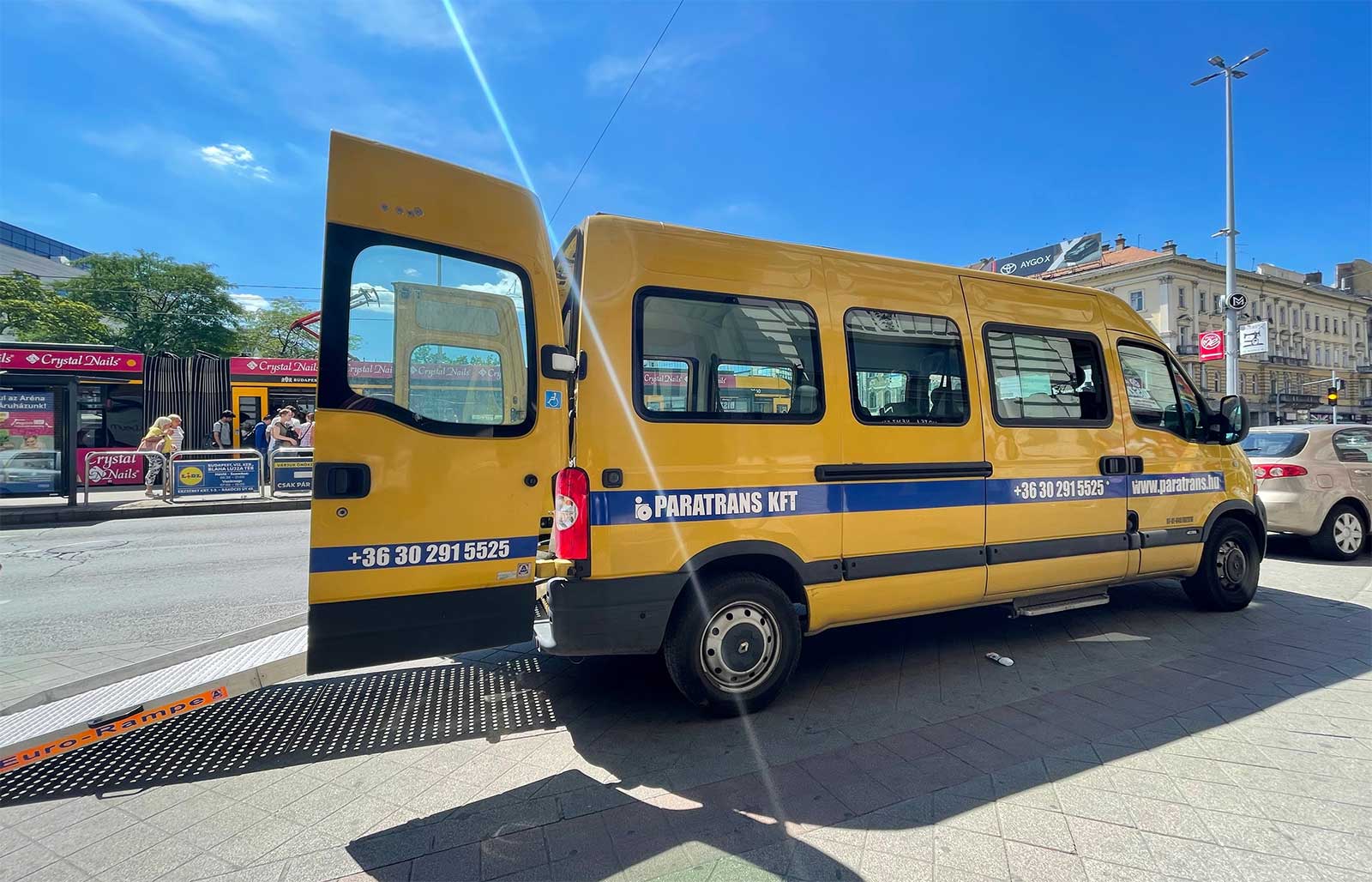 Yellow van with wheelchair ramp at rear.