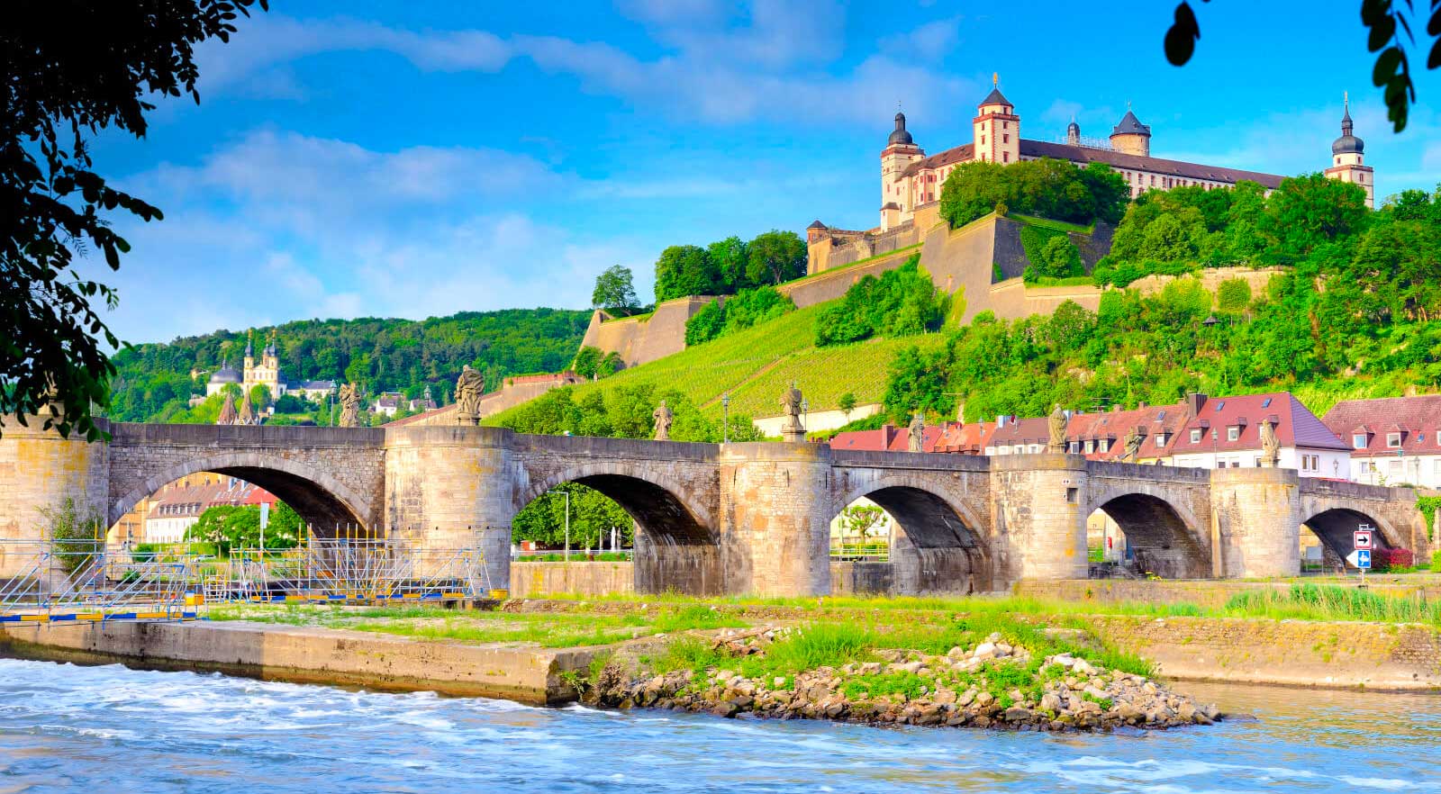 Wurzburg skyline with castle on hilltop and bridge over river.