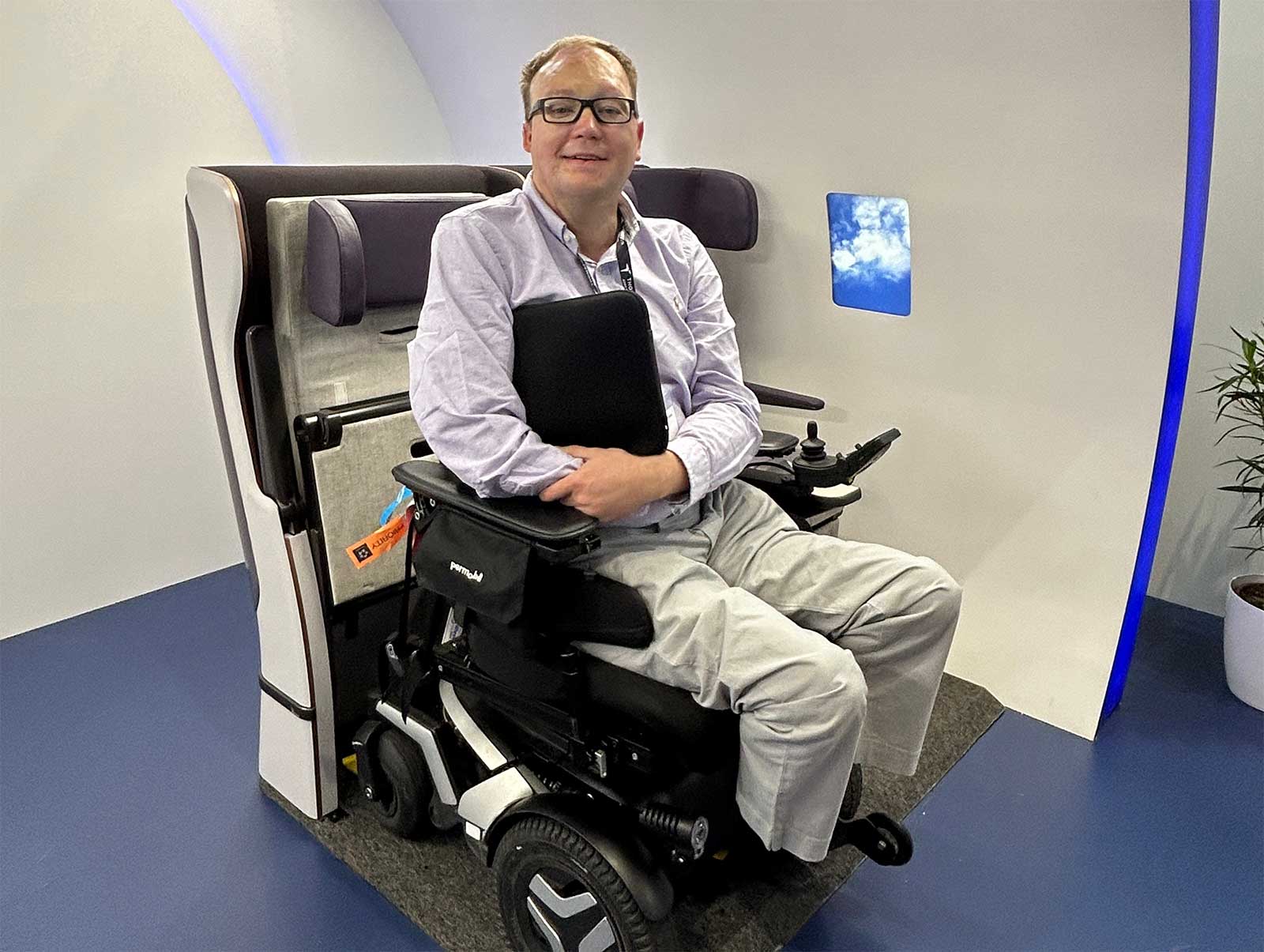 John in his Permobil F3 backed partially into wheelchair securement space.