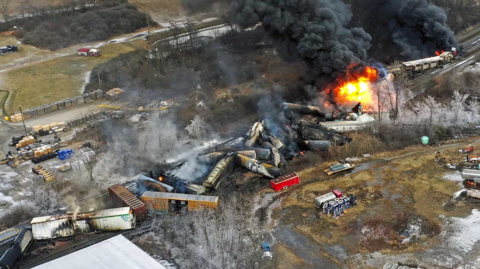 Overhead view of a derailed train in Ohio, with cars strewn about and on fire.