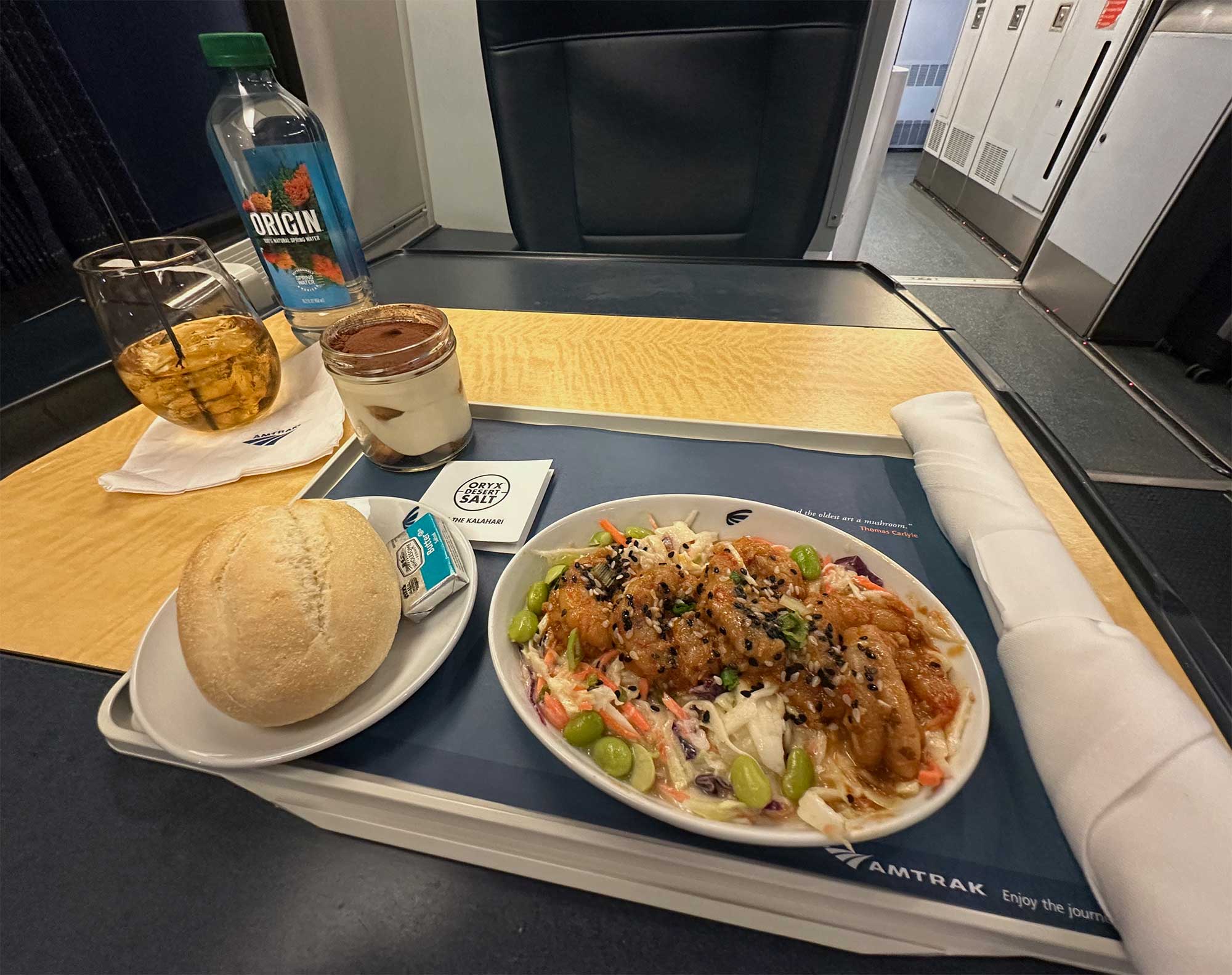 Shrimp, bread and dessert served on a tray in Acela first class.