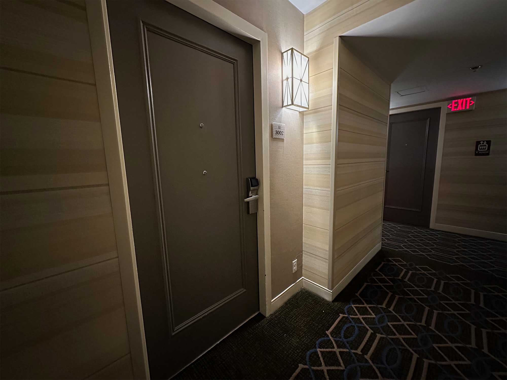 Hotel room door in carpeted hallway.