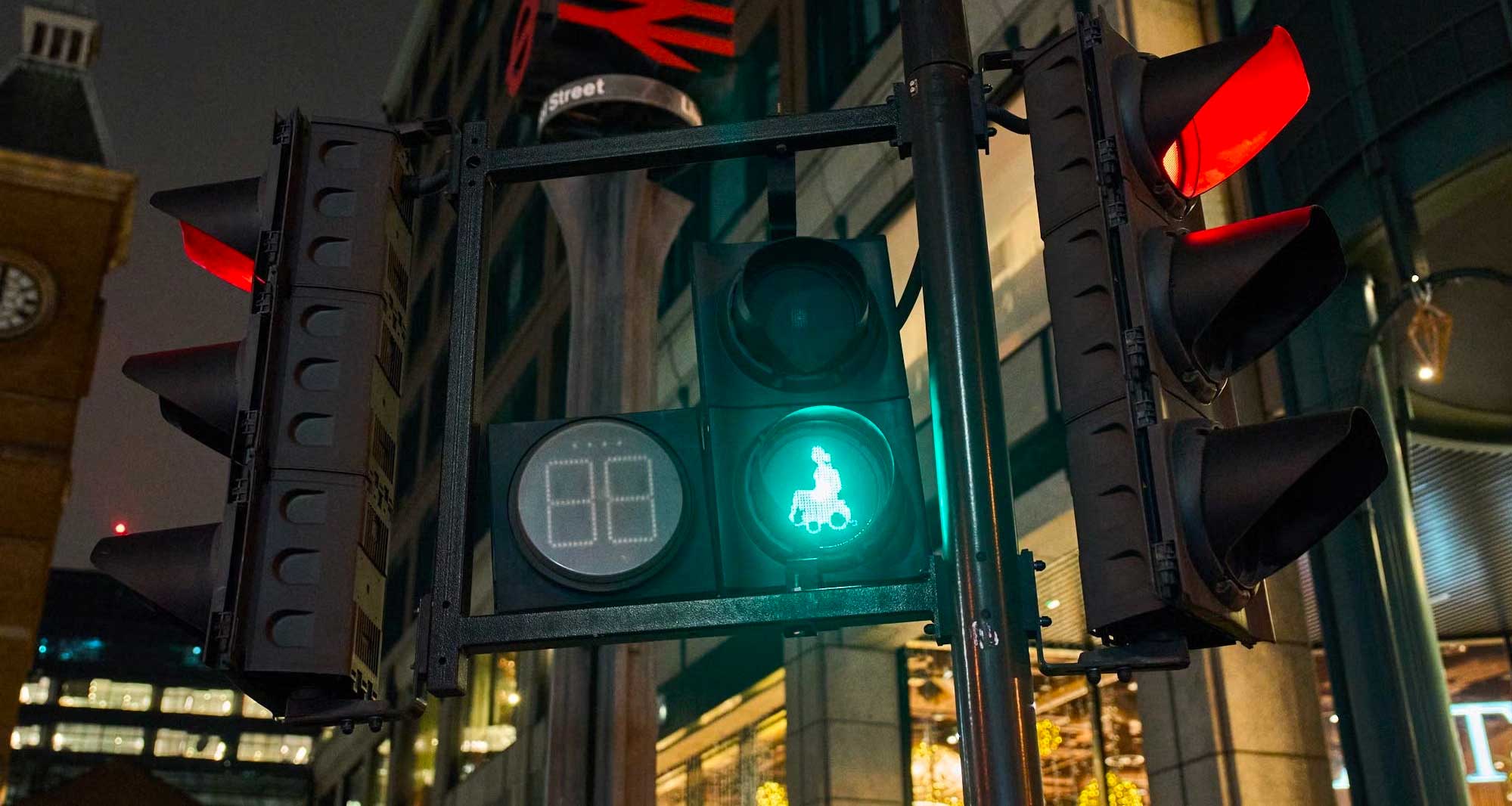 Pedestrian crossing signal with illuminated wheelchair icon.